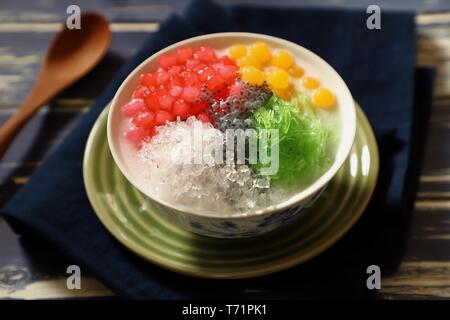 Asiatique de dessert glacé Thai red ruby pearls, bubble jelly, agar agar, nouilles, graines de basilic et glace pilée dans le lait de coco soupe. Banque D'Images