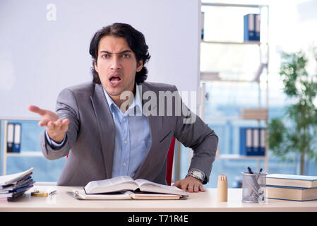 Beau jeune enseignant devant de tableau blanc Banque D'Images