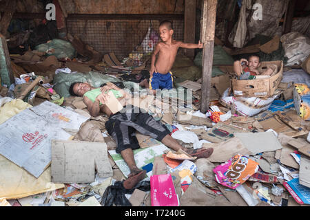 Les enfants vivant dans Tondo, nord ouest de Manille aux Philippines et l'un des plus densément peuplés des morceaux de terre dans le monde, de prendre une pause de la collecte de matériaux abandonnés tels que les bouteilles en plastique, et de restaurants fast food reste qui est recooked et vendus comme 'Pagpag. Banque D'Images