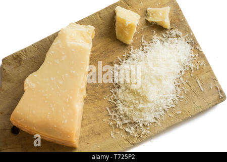 Fromage parmesan râpé sur fond blanc sur une planche en bois, cuisine italienne. Banque D'Images