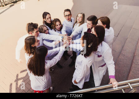 L'éducation et la santé. Programme d'aide médical. Un groupe d'étudiants en médecine à puce college. Les stagiaires d'amis sur le site de l'arrière-plan de l'hôpital. Banque D'Images