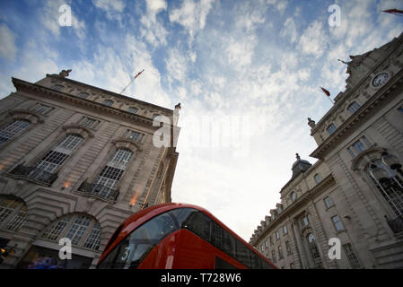 Low angle shot dynamique de conduite des bus à impériale rouge dans le centre-ville de Londres sur Oxford Street et Regent Street dans le soleil d'été Banque D'Images