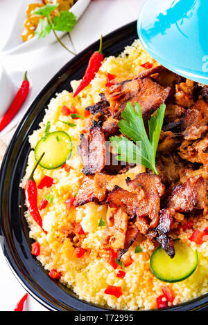 Tajin avec du couscous, légumes et viande sur fond blanc Banque D'Images