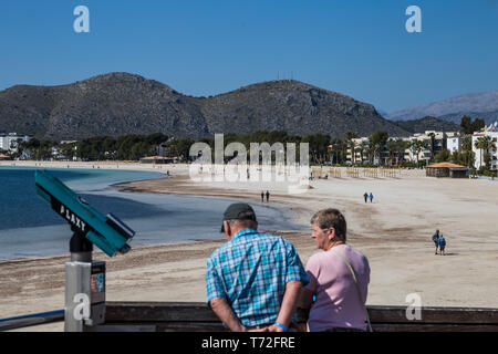 Un couple de personnes âgées à pied sur la promenade à Port d'Alcudia, Mallorca, Espagne. Banque D'Images