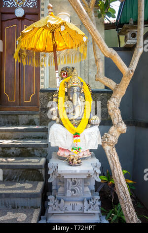 Guirlande de fleurs d'or drapées autour de Ganesha Banque D'Images