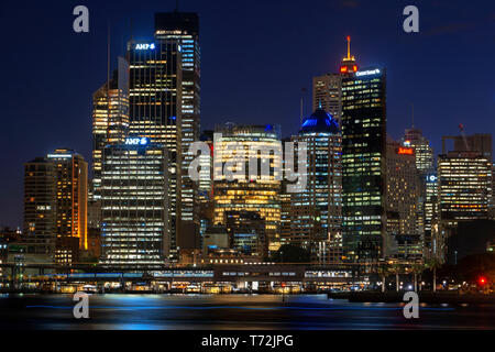 L'architecture. Première ligne de bâtiments dans la ville de Sydney CBD au coucher du soleil. Passage du pont illuminé se reflétant dans les eaux trouble Sydney, New South Wale Banque D'Images