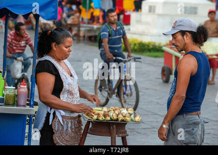 Femme vendant des épis de maïs grillés, wc séparés dans la ville coloniale de Granada Nicaragua Amérique Centrale. Vendeur alimentaire étal dans le Parque Central i Banque D'Images