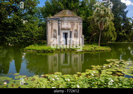 Le jardin anglais de la "Reggia di Caserta" a quelques fausses ruines, comme ce temple ruine sur une petite île au milieu d'un étang avec des nénuphars. Banque D'Images