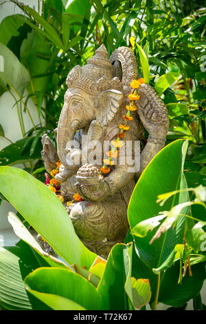 Guirlande de fleurs d'or drapées autour de Ganesha Banque D'Images