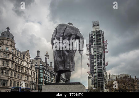 Les échafaudages vers les Maisons du Parlement enveloppant la Tour de la Reine Elizabeth et Big Ben dominé par une statue de Winston Churchill Banque D'Images