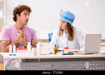 Jeune homme séduisant jeune femme médecin oto-rhino-laryngologiste visite Banque D'Images