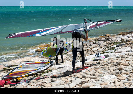 Surf en préparation sur une plage rocheuse Banque D'Images