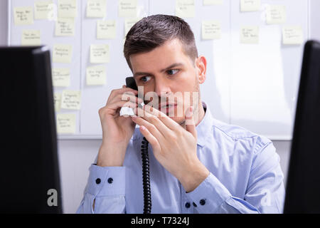 Young Woman at Office Téléphone fixe Banque D'Images