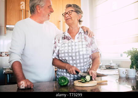 Heureux retraité senior vieux beaux cheveux blancs ou deux personnes ensemble de cuisson à la maison dans la cuisine couper des légumes pour une alimentation saine vie c Banque D'Images