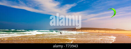 Les surfeurs à Praia da Bordeira beach près de Carrapateira, Portugal. Kiteboarder kitesurfer sportif effectuant le kitesurf kiteboarding astuces. Praia da Bo Banque D'Images