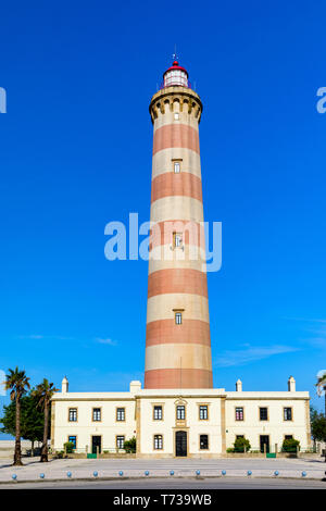 Phare de Praia da Barra pendant la journée, avec un ciel bleu clair. Vue sur le phare de Barra Beach (Praia da Barra) à Aveiro, Portugal. Banque D'Images