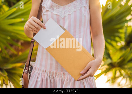 Mains de femmes dans un contexte tropical avec une pancarte papier, immersive Banque D'Images