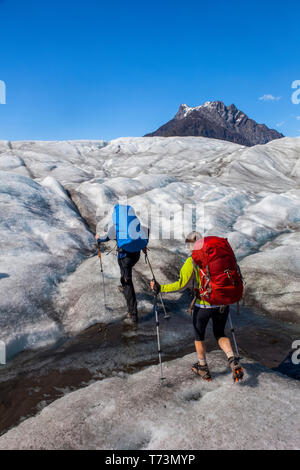 Couple de randonnée à travers le glacier racine avec des crampons pendant l'été vers Donoho Peak, Wrangell Mountains, Wrangell-St.Parc national d'Elias... Banque D'Images