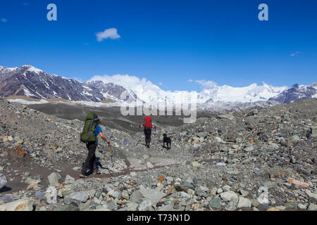 Couple et leur chien backpacking à travers la moraine du glacier Kennicott, montagnes Wrangell, Wrangell-St. Elias National Park, le centre-sud de l'Alaska Banque D'Images
