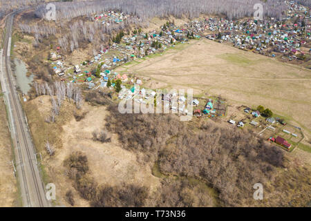 Vue de dessus d'un grand village avec des petites maisons,, une forêt verte et un grand champ dans un jour d'été chaud et ensoleillé. Drone hélicoptère abattu. Banque D'Images