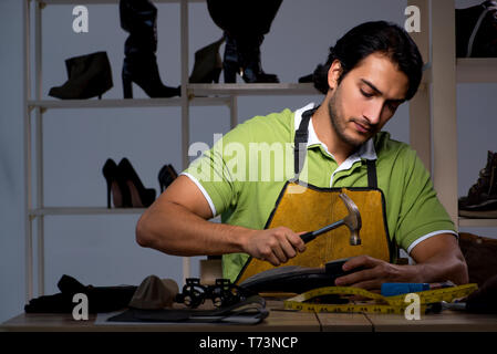 Les jeunes dans la nuit de l'atelier de cordonnier Banque D'Images