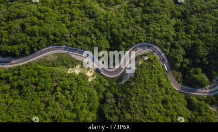 Vue aérienne de haut en bas : des voitures roulant sur route de montagne sinueuse zig zag Banque D'Images