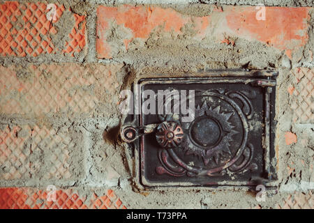 Rusty porte métallique fermé en brique rouge fournaise fuligineux Banque D'Images