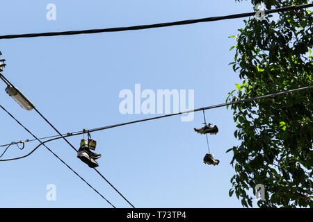 Deux paires de chaussures qui pendait au-dessus de la ligne téléphonique. Banque D'Images