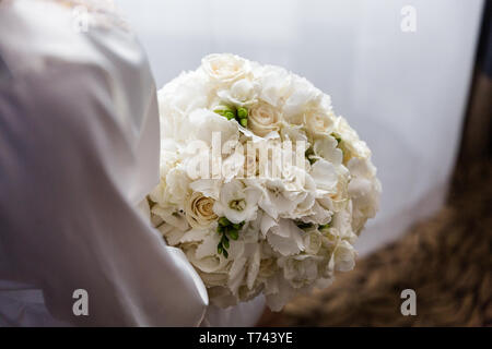 Bouquet de mariée exquise de fleurs blanches de roses, hortensias et de freesia dans les mains Banque D'Images