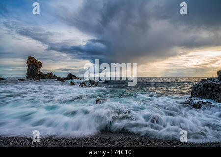 Les vagues déferlent sur le rivage de Djupalonssandur beach au coucher du soleil, la péninsule de Snaefellsness Islande ; Banque D'Images