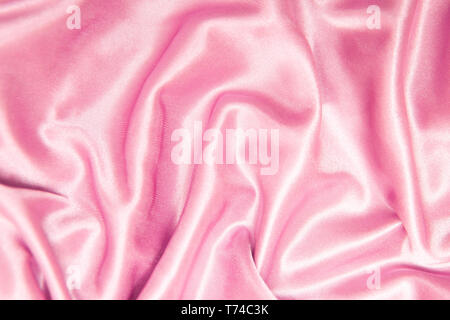 Et la texture textile concept - close up de soie tissu froissé rose fond ondulé Banque D'Images