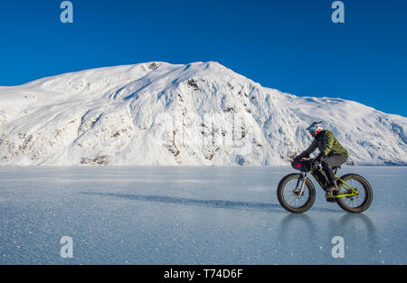 Un homme monté sur son fatbike congelés au lac Portage au milieu de l'hiver dans le centre-sud de l'Alaska ; Alaska, États-Unis d'Amérique Banque D'Images