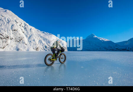 Un homme monté sur son fatbike congelés au lac Portage au milieu de l'hiver dans le centre-sud de l'Alaska ; Alaska, États-Unis d'Amérique Banque D'Images