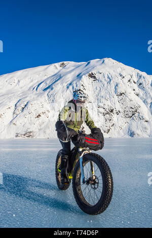 Un homme monté sur son fatbike congelés au lac Portage au milieu de l'hiver dans le centre-sud de l'Alaska ; Alaska, États-Unis d'Amérique Banque D'Images