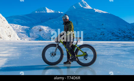 Un homme monté sur son fatbike congelés au lac Portage au milieu de l'hiver dans le centre-sud de l'Alaska ; Alaska, États-Unis d'Amérique Banque D'Images