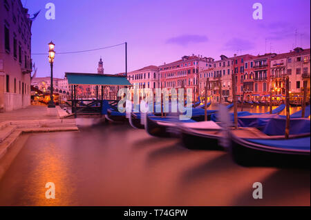 Gondoles amarré le long de la rive du Grand Canal lors d'un coucher du soleil ; Venise, Italie Banque D'Images