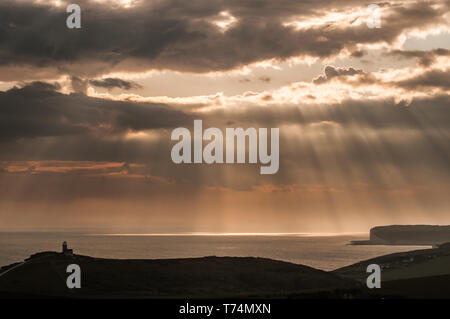 Eastbourne, East Sussex, Royaume-Uni. 3 mai 2019. Les rayons à travers le nuage de plus en plus couvert près du coucher du soleil font une scène étonnante. Photo prise de Beachy Head en regardant vers l'ouest avec le phare de Belle tout à gauche, Birling Gap à droite de la photo. Banque D'Images