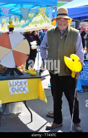 Distributeur de billets pour la course de canard tenant un canard en caoutchouc jaune à la foire de Cuckoo du centre-ville près de Salisbury, Royaume-Uni, 4 mai 2019, la foire annuelle de rue a lieu le long de la Borough dans le village du sud du Wiltshire. Banque D'Images