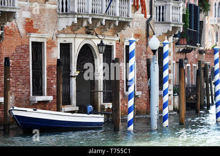 Canal de Venise en Italie. Un bateau est blottie à une station d'accueil personnels devant une maison où l'eau vient jusqu'à la porte. Banque D'Images