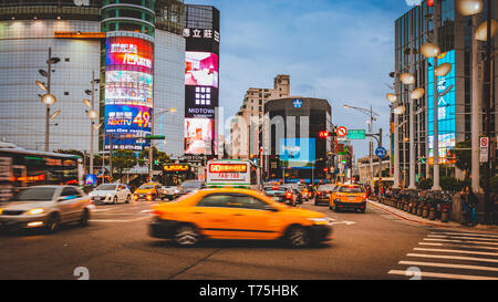 Flou de carrefour en face de Ximending district commercial à Taipei pendant le crépuscule Heure bleue avec le taxi de passage. Banque D'Images