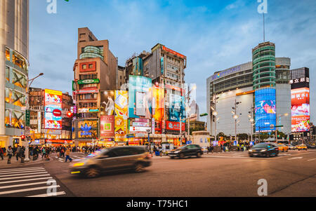 Taipei, Taïwan : flou de carrefour en face du quartier commerçant à Taipei Ximending pendant le crépuscule Heure bleue avec taxi passant Banque D'Images