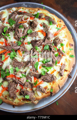 Hot big pizza au pepperoni pizza savoureuse composition avec bacon jambon fromage fusion tomates paprika fumée vapeur sur fond noir Banque D'Images