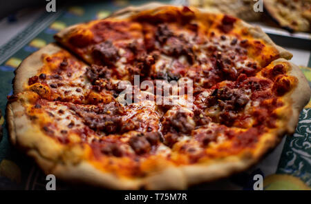 Hot big pizza au pepperoni pizza savoureuse composition avec bacon jambon fromage fusion tomates paprika fumée vapeur sur fond noir Banque D'Images