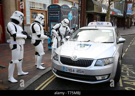 Veuillez NOTER QUE LES ÉDITEURS L'éclaireur de PLAQUE A ÉTÉ PIXELISÉES PAR L'AP PHOTO 24 À LA DEMANDE DU CONDUCTEUR. Acteurs Cosplay déguisés en Stormtroopers posent pour une photo comme ils héler un taxi cab en dehors de la Comic Con de Portsmouth à Portsmouth Guildhall. Banque D'Images