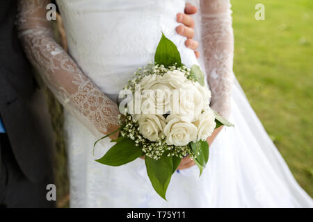 Méconnaissable bride holding a bouquet de mariage raffiné de roses blanches et de Grand Gaube Banque D'Images