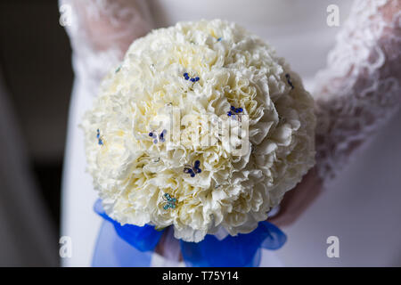 Méconnaissable bride holding a bouquet de mariage raffiné de pivoines blanches avec du ruban bleu Banque D'Images