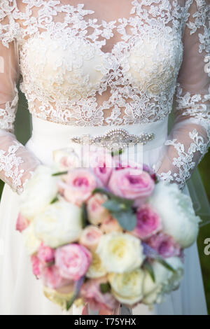 Méconnaissable bride holding a bouquet de mariage raffiné de roses roses et blanches avec pivoines Banque D'Images