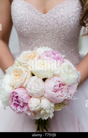 Méconnaissable bride holding a bouquet de mariage raffiné de pivoines rose et blanc avec des roses Banque D'Images