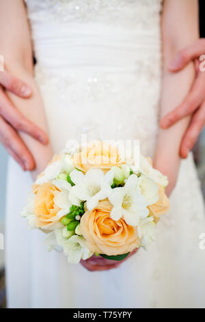 Méconnaissable bride holding a bouquet de mariage raffiné de roses jaunes de freesia blanc Banque D'Images