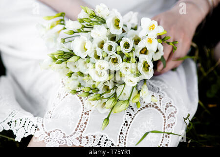 Bouquet de mariée exquise d'eustoma Blanche-neige dans les mains d'une femme méconnaissable Banque D'Images